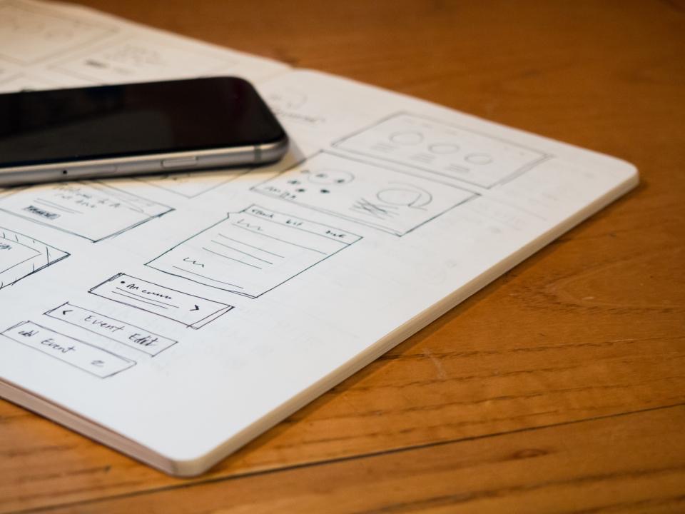 Interface sketches and device mockups on a desk